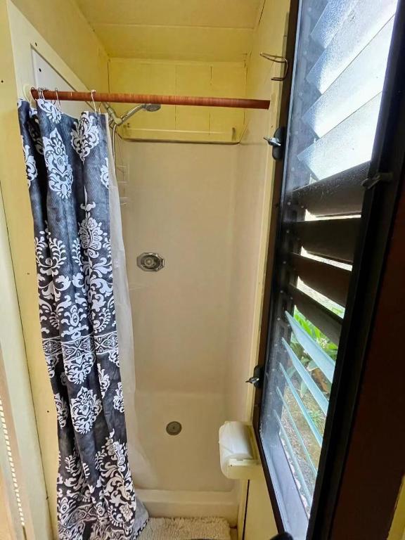 a shower curtain in a bathroom with a window at Coffee Garden in Captain Cook