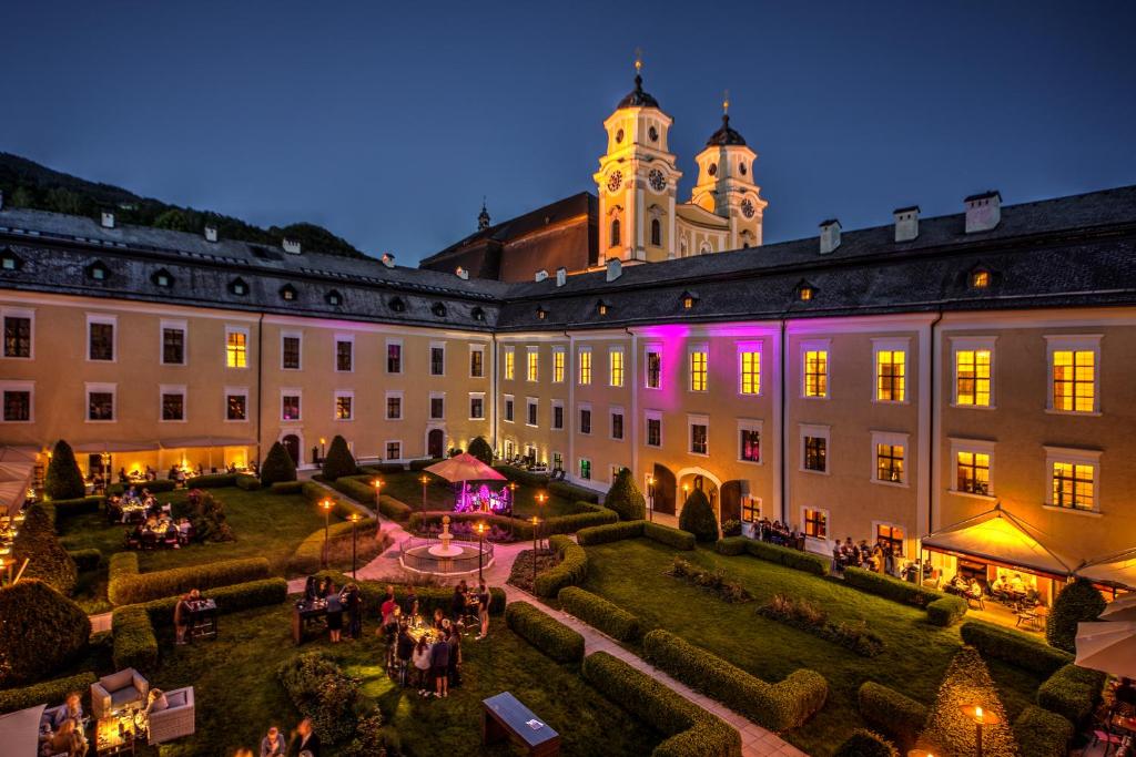 a large building with a garden and a clock tower at Schlosshotel Mondsee in Mondsee