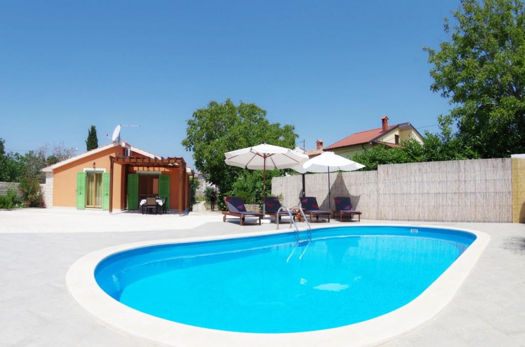 basen z dwoma krzesłami i parasolem w obiekcie House Elvis, Sveti Kirin w mieście Vodnjan