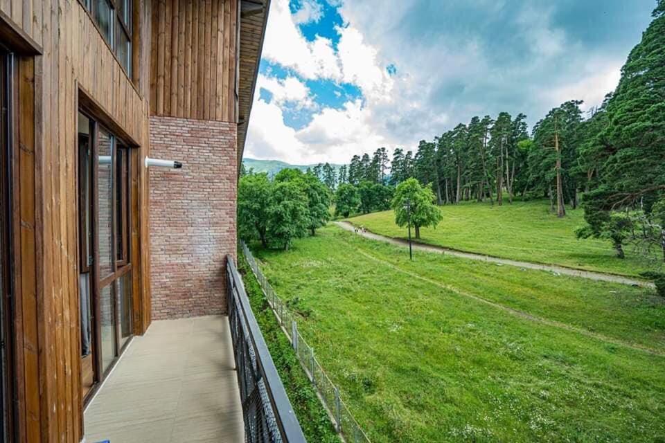 a house with a balcony with a view of a field at Park Residence Forest View in Bakuriani