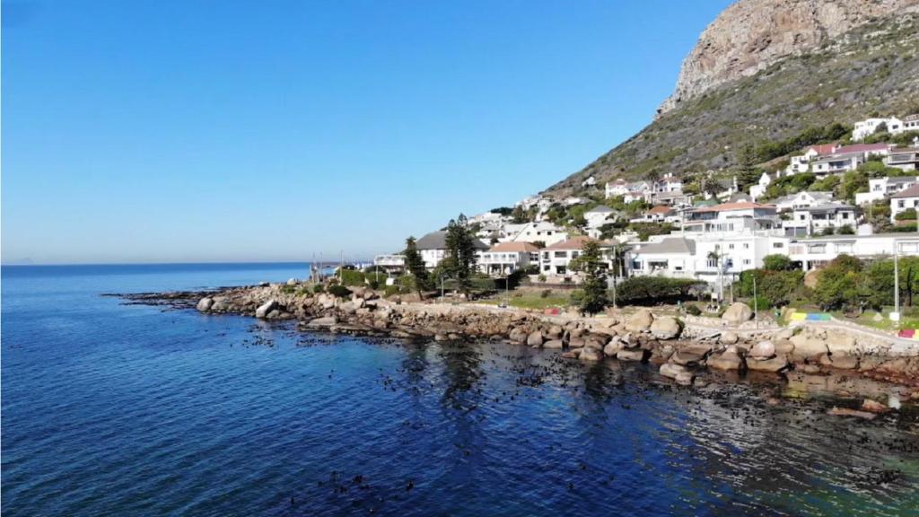 a group of houses on a hill next to the water at Paradise On the Bay in Fish hoek