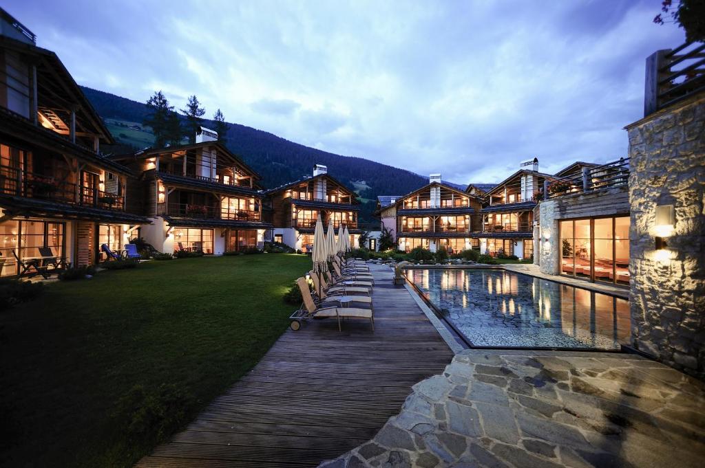 a large house with a pool in front of it at Post Alpina - Family Mountain Chalets in San Candido