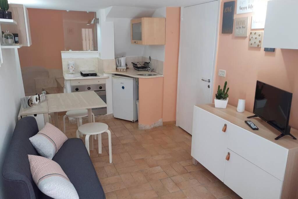 a kitchen and a living room with a couch and a table at La Casetta - Casa Indipendente nel centro storico in Fermo