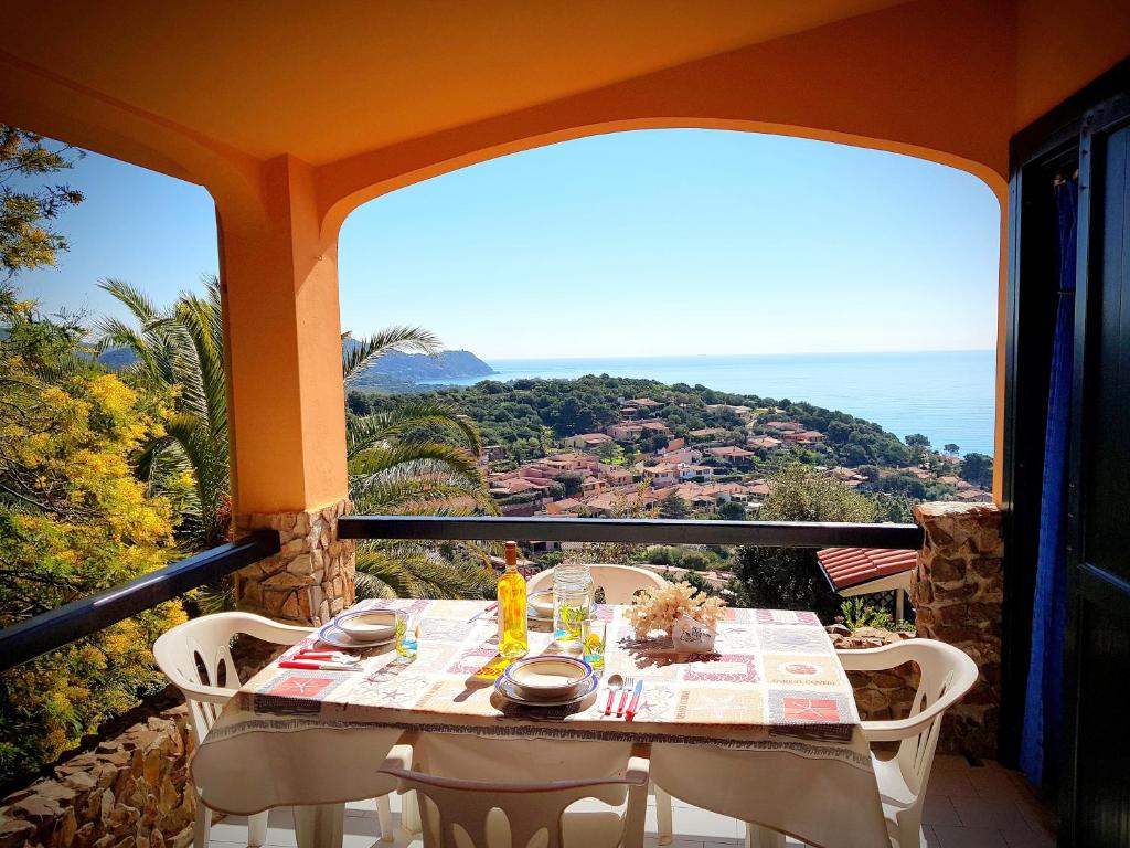 un tavolo su un balcone con vista sull'oceano di Villino Mari Pintau Best Vacation Ever a Geremèas