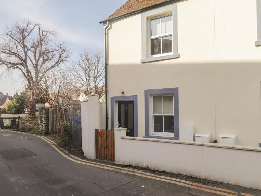 a white house with a window on a street at Hope Cottage in Hythe