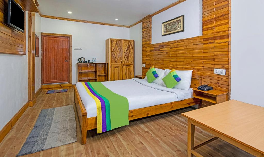 ein Schlafzimmer mit einem Bett und einer Holzwand in der Unterkunft Treebo Trend Omega Stay Inn in Shillong