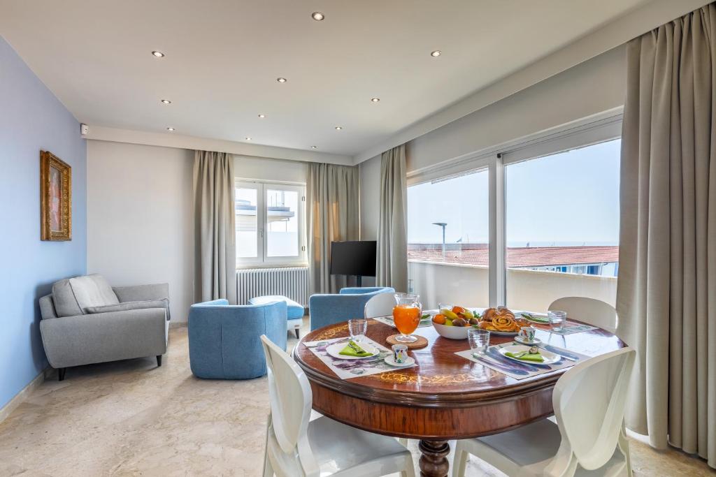 een woonkamer met een eettafel met stoelen bij Viareggio Suite - Sea view apartment in Viareggio