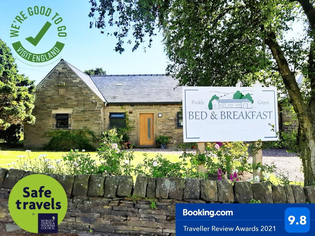 a sign for a bed and breakfast in front of a house at Finkle Green B & B in Wortley