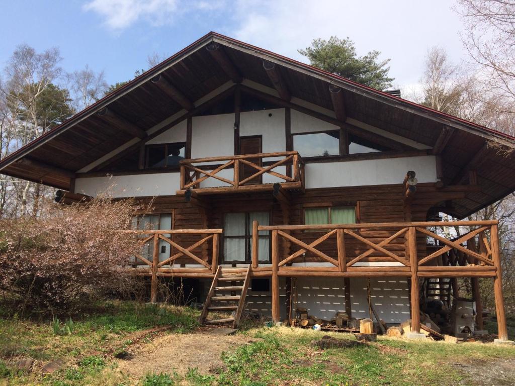 a house on a hill with a wooden structure at NaGano-log house in Chino