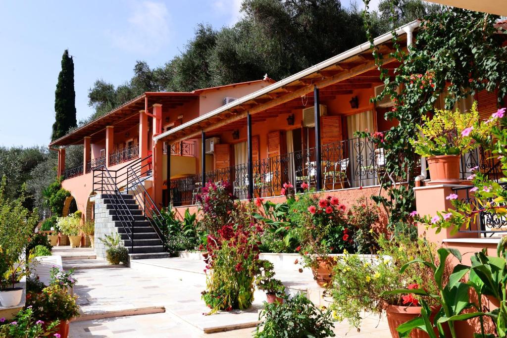 un bâtiment avec des fleurs et des plantes devant lui dans l'établissement Paradise Studios, à Paleokastritsa