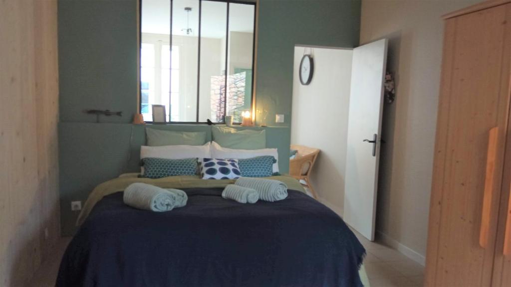 1 dormitorio con cama con sábanas azules y ventana en T2 D en coeur de Balaruc dans maison avec jardin ideal couple de curistes en Balaruc-les-Bains