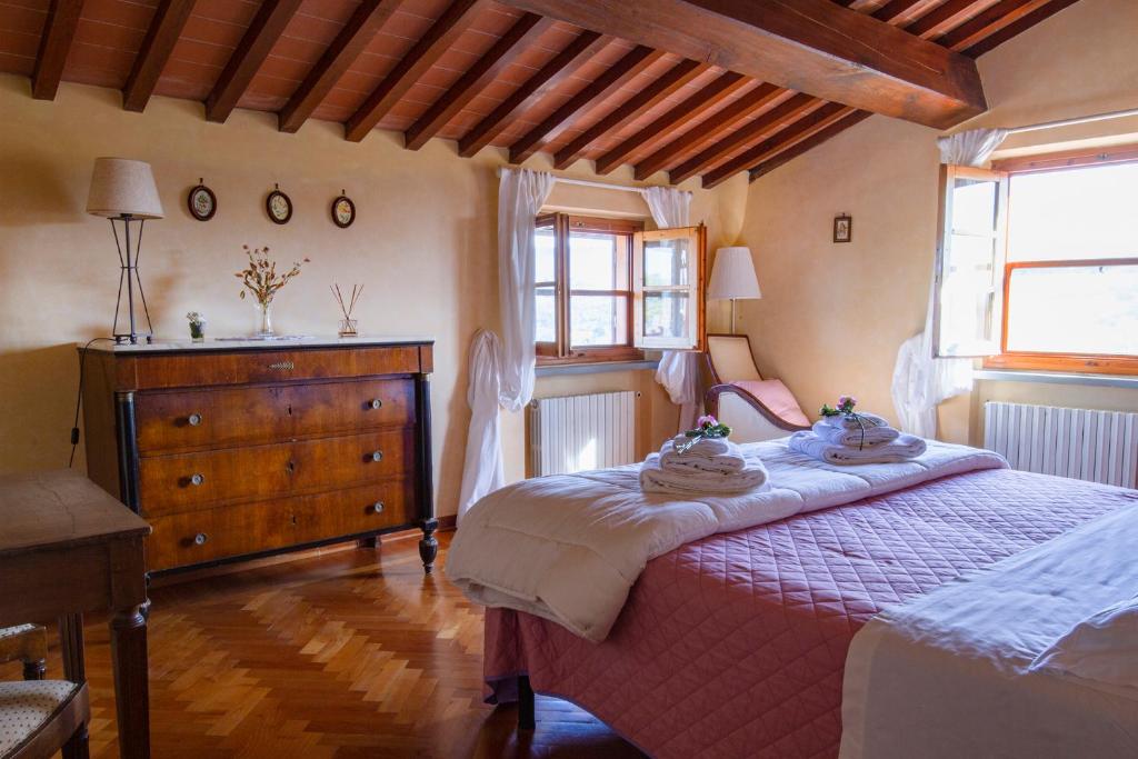 a bedroom with a bed and a dresser and a window at Rosso Del Chianti in Panzano