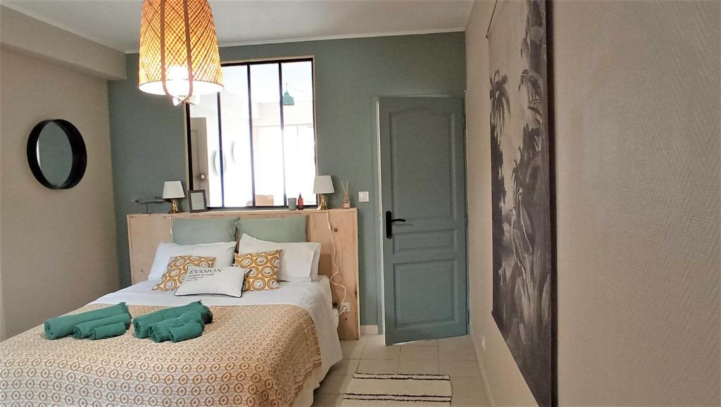 een slaapkamer met een bed met kussens erop bij T2 G dans maison en centre ville avec jardin ideal couple curistes in Balaruc-les-Bains