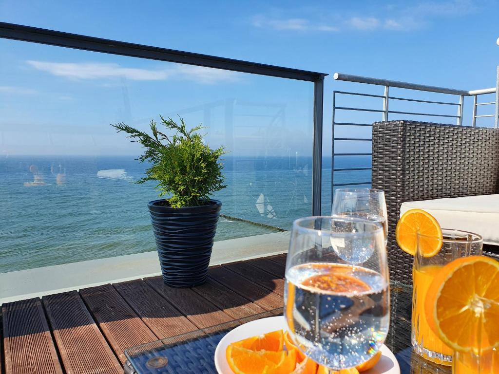 a table with glasses of water and oranges on a balcony at Boulevard - 365PAM in Ustronie Morskie