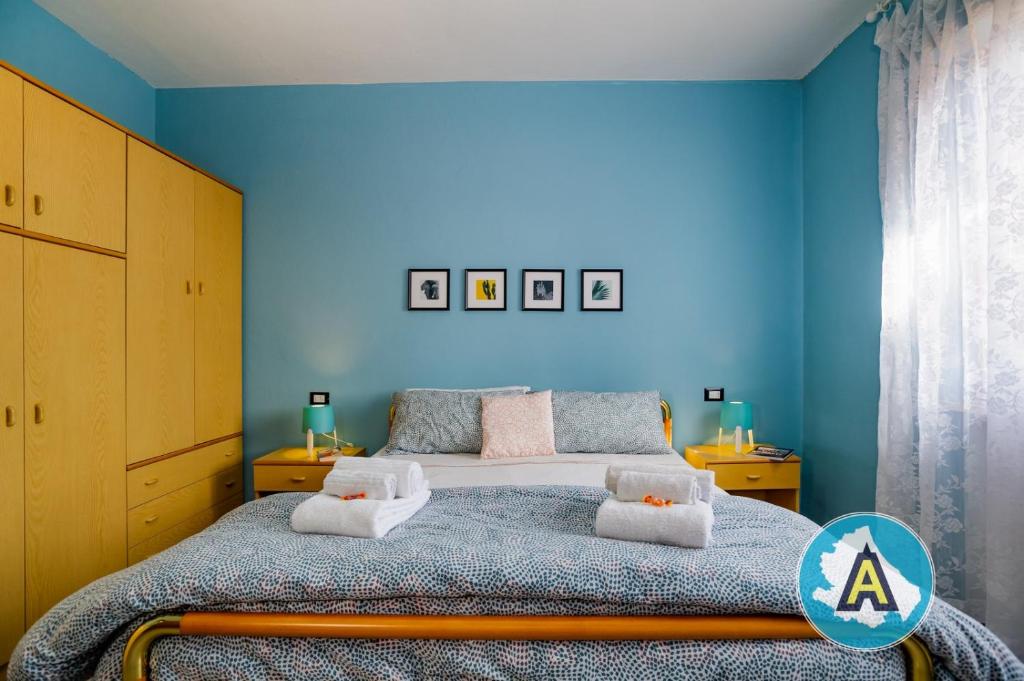 - une chambre bleue avec un lit et des serviettes dans l'établissement Appartamento Centrale a Silvi Marina, à Silvi Marina