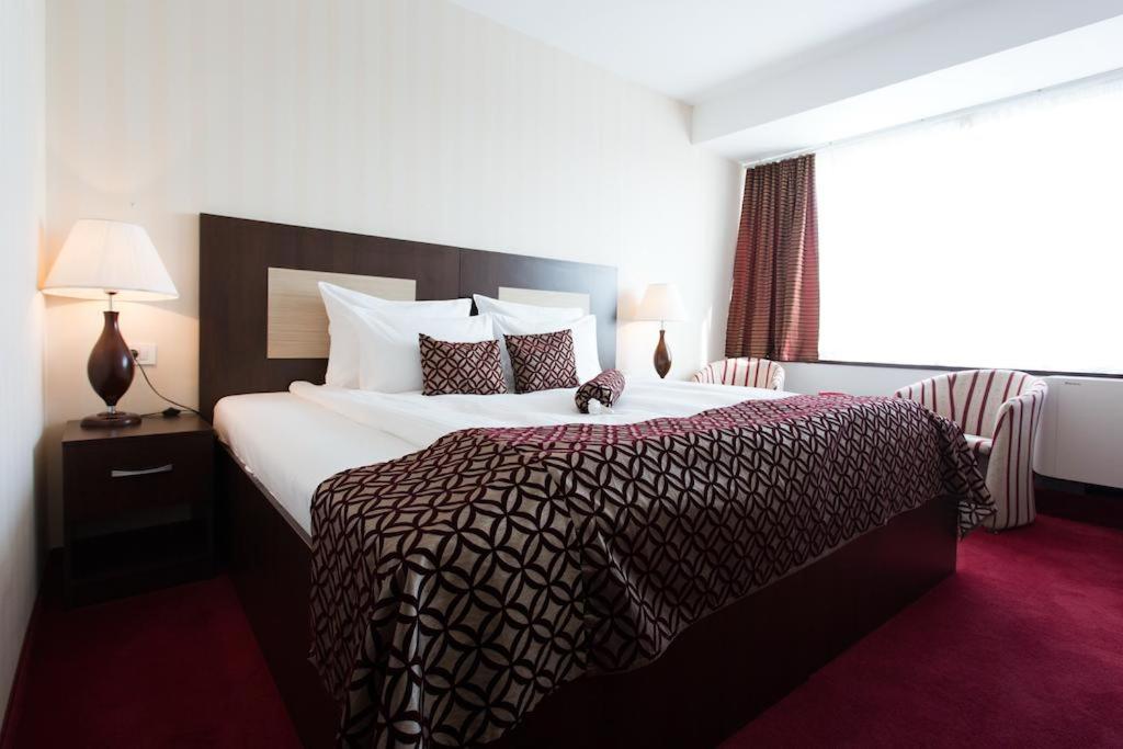 Postel nebo postele na pokoji v ubytování Grand Hotel Napoca