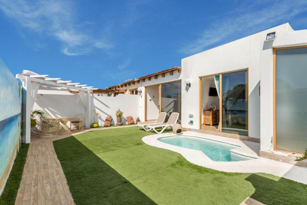 un jardin avec une piscine et une maison dans l'établissement Villa Bali, à Playa Blanca