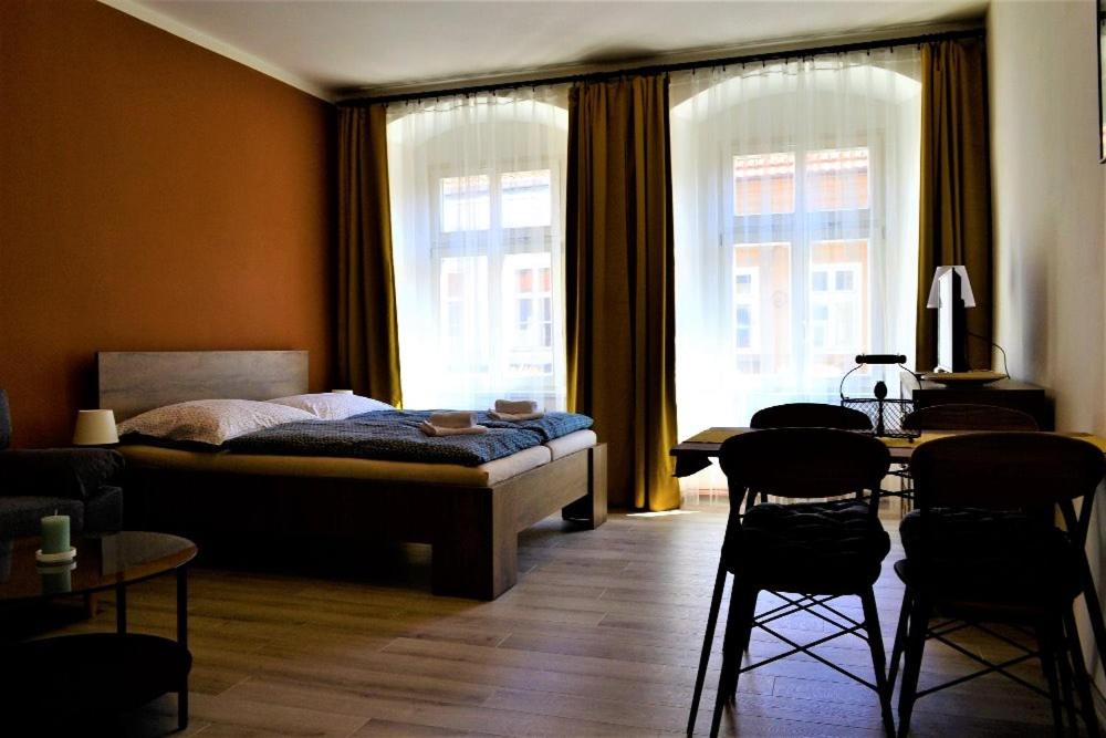 een slaapkamer met een bed en een tafel en stoelen bij Pension Kotva in Beroun