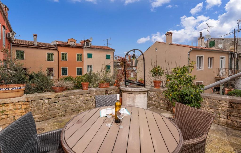 a wooden table and chairs on a patio with buildings at Apartments Tizi Rovinj in Rovinj