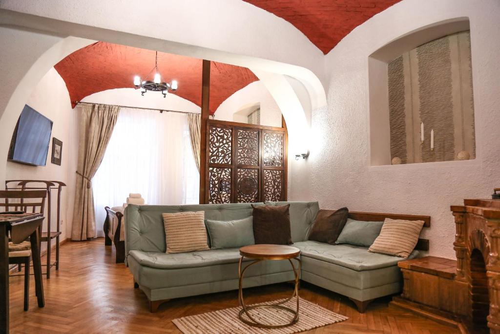 ein Wohnzimmer mit einem Sofa und einem Tisch in der Unterkunft Residence Krone in Braşov