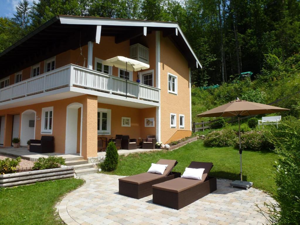 ein großes Haus mit einer Terrasse und einem Sonnenschirm in der Unterkunft Haus Irlinger in Schönau am Königssee