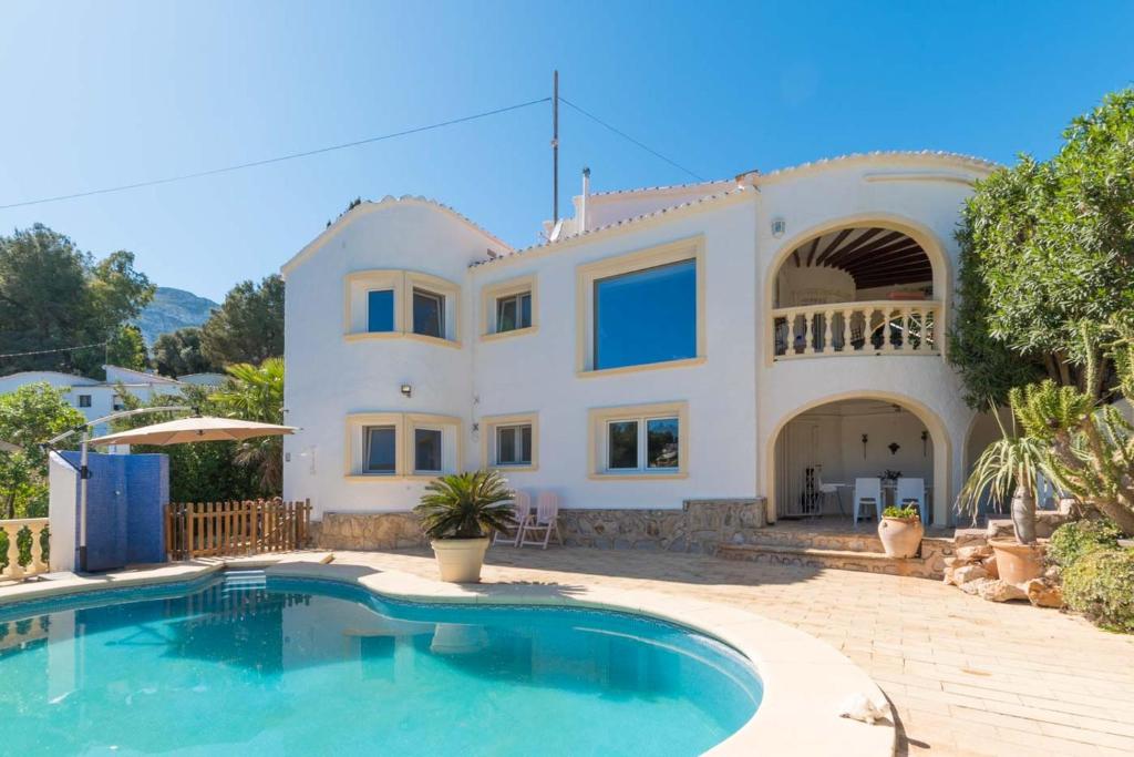een huis met een zwembad ervoor bij Casa Mar y Montaña in Denia