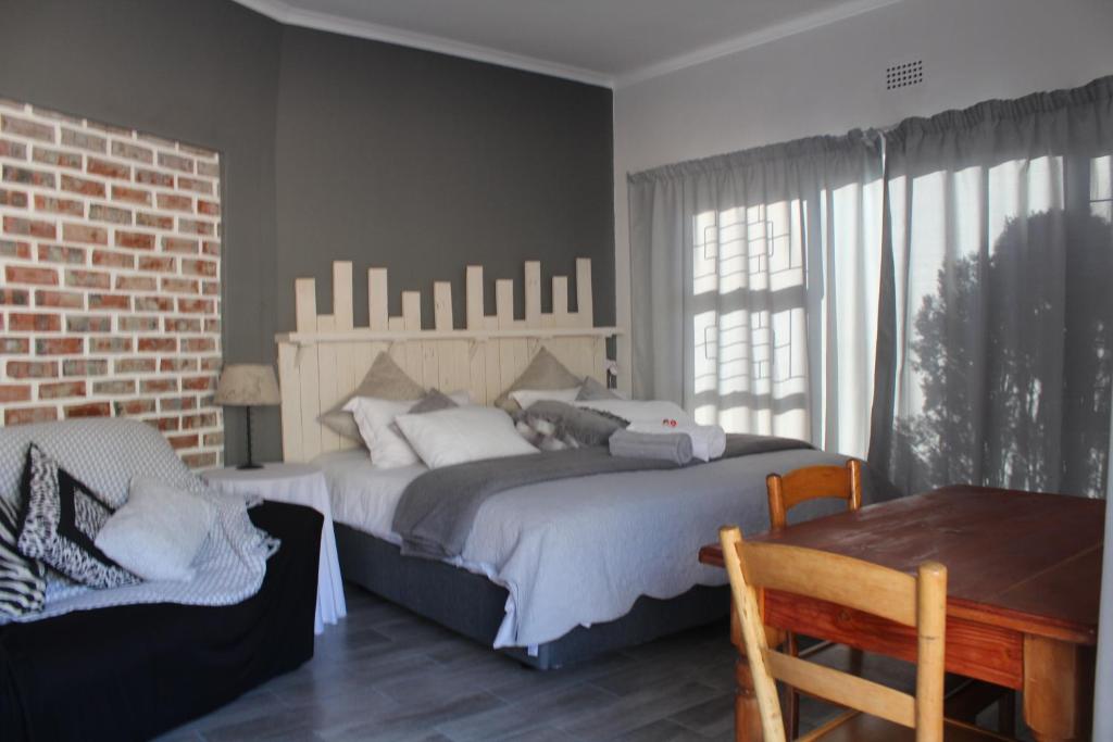 a bedroom with a large bed and a table at 19 on Micro Avenue in Strand