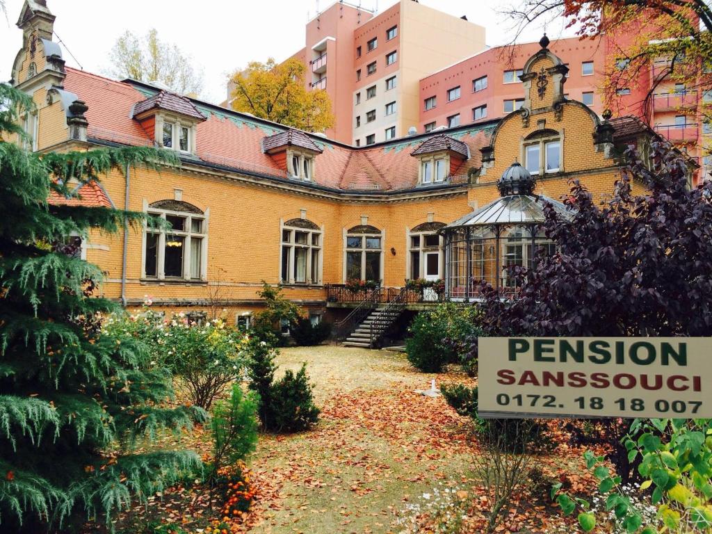 ein altes Haus mit einem Schild davor in der Unterkunft Pension Sanssouci in Potsdam