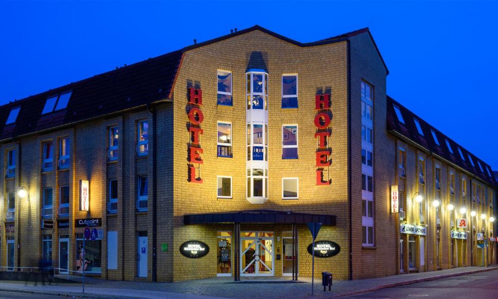 a large brick building on a street at night at Hotel Märkischer Hof in Luckenwalde