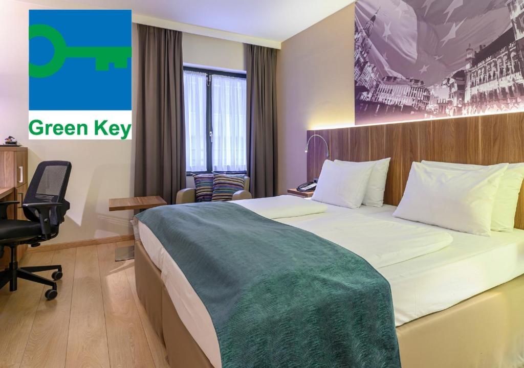 a hotel room with a bed with a green key sign on the wall at Holiday Inn Brussels Schuman, an IHG Hotel in Brussels