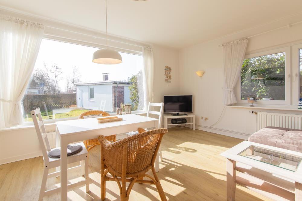 een woonkamer met een witte tafel en stoelen bij Ferienhaus Kleeblatt 5 - Zentrale, ruhige Lage mit Garten und Terrasse in Scharbeutz