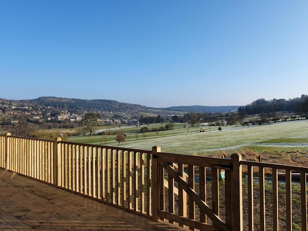 a wooden fence with a field in the background at Fairway View Cottage in Rothbury