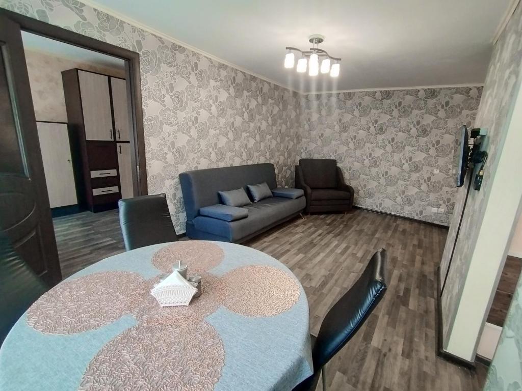 a living room with a table and a couch at ДЕНЬ И НОЧЬ Ленина, 40 in Kaluga