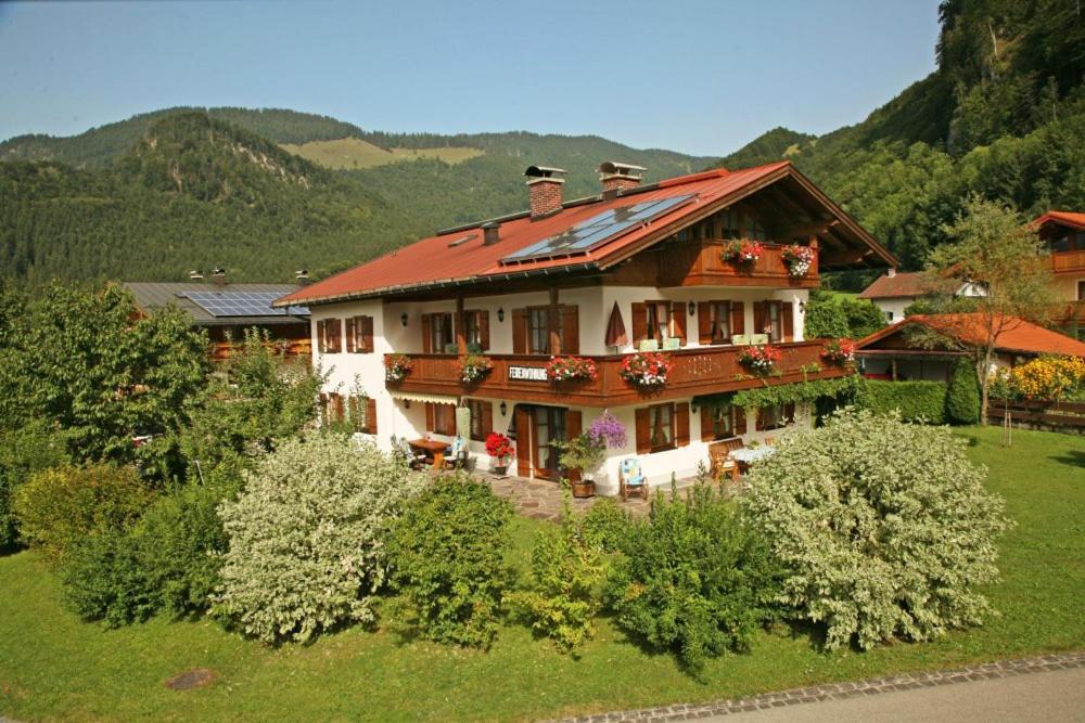 una casa con techo rojo en un campo verde en Haus Kohlpointner, en Oberwössen