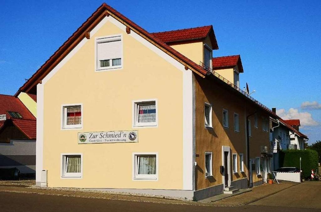 a building with a sign on the side of it at Pension zur Schmied'n in Marzling