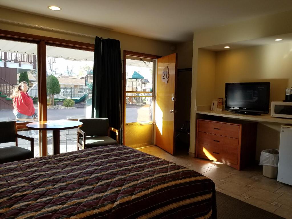 una camera d'albergo con un letto, un tavolo e una televisione di Black Hawk Motel & Suites a Wisconsin Dells