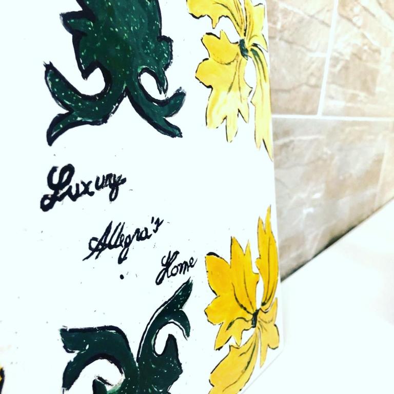 a greetings card with yellow flowers on a tile wall at Luxury Allegra’s home in Syracuse