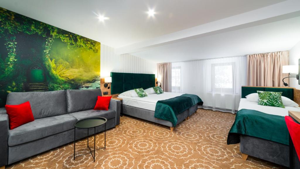 pokój hotelowy z 2 łóżkami i kanapą w obiekcie Leśny Dwór w mieście Karpacz