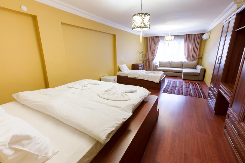 a hotel room with two beds and a couch at istanbul enjoyer suit in Istanbul
