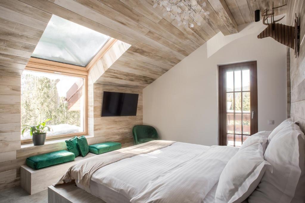 - une chambre avec un grand lit et une fenêtre dans l'établissement Sidharta Resort, à Obarsia-Lotrului