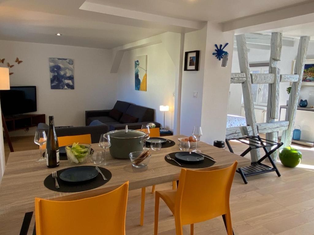 uma sala de estar com uma mesa de jantar e cadeiras em DUPLEX Le 12 - Appartement avec terrasse dans le vignoble - 5 mn du centre de Colmar em Wettolsheim