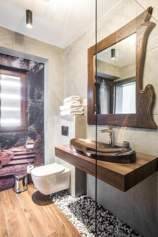 un bagno con lavandino e specchio di Sidharta Resort a Obârşia Lotrului
