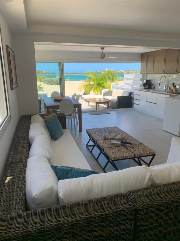 ein Wohnzimmer mit einem weißen Sofa und einem Tisch in der Unterkunft Coco Beach in Saint Martin
