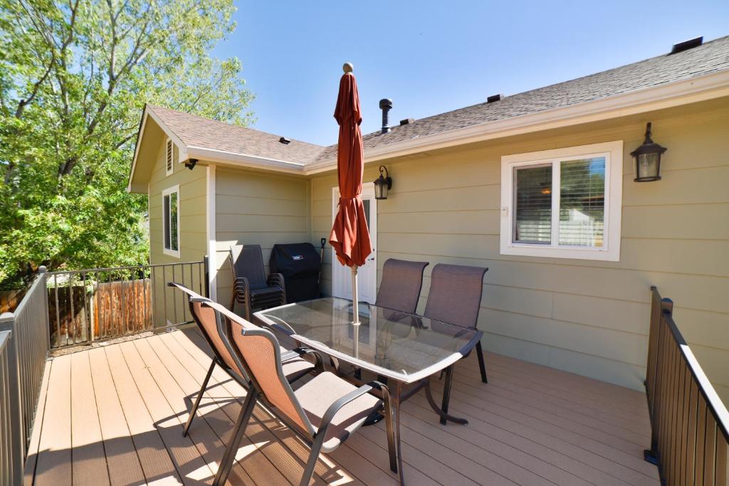 a deck with a table and chairs and an umbrella at 1208_Westmoreland in Colorado Springs