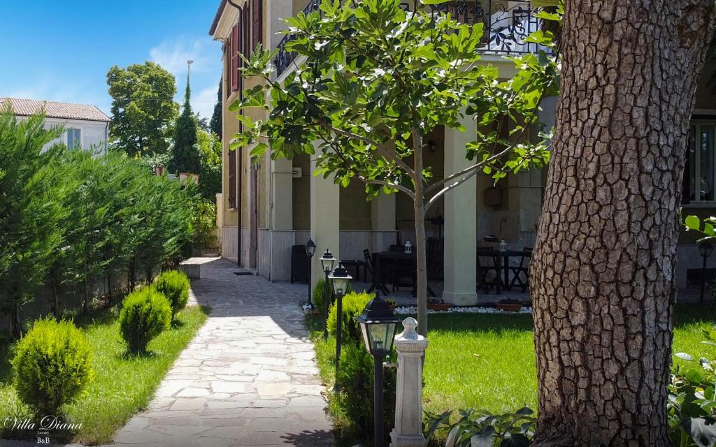 a walkway in front of a building with a tree at B&B Villa Diana in Sulmona