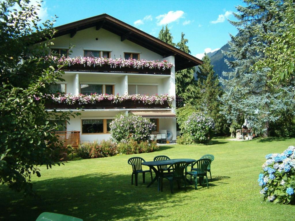 una mesa y sillas frente a un edificio en Gästehaus Ahornblick, en Mayrhofen