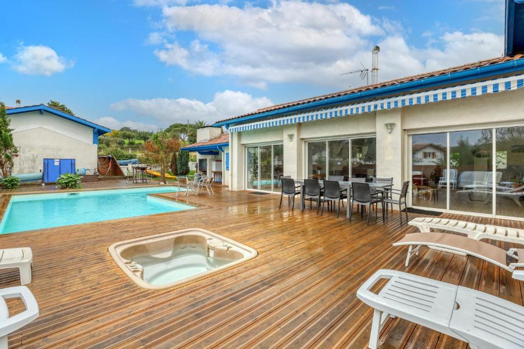 a large deck with a swimming pool and a house at Villa spacieuse à Bidart avec piscine privée 330 m² in Bidart