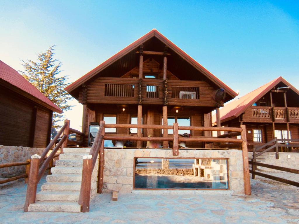 a large log cabin with a staircase in front of it at Mountain Chalet in Covilhã