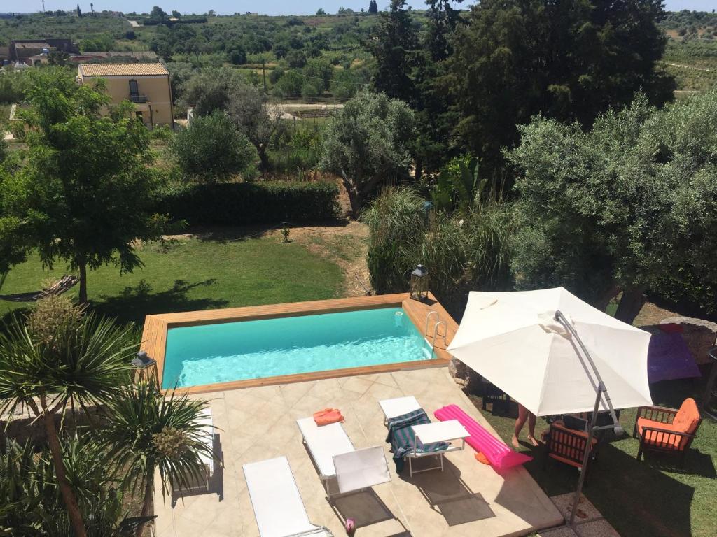 an overhead view of a pool with chairs and an umbrella at Country Loft Siracusa in Syracuse