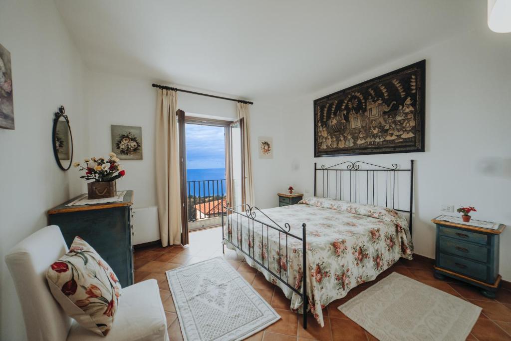 ein Schlafzimmer mit Bett und Blick auf das Meer in der Unterkunft Residenza Golfo Degli Ulivi in Caprioli